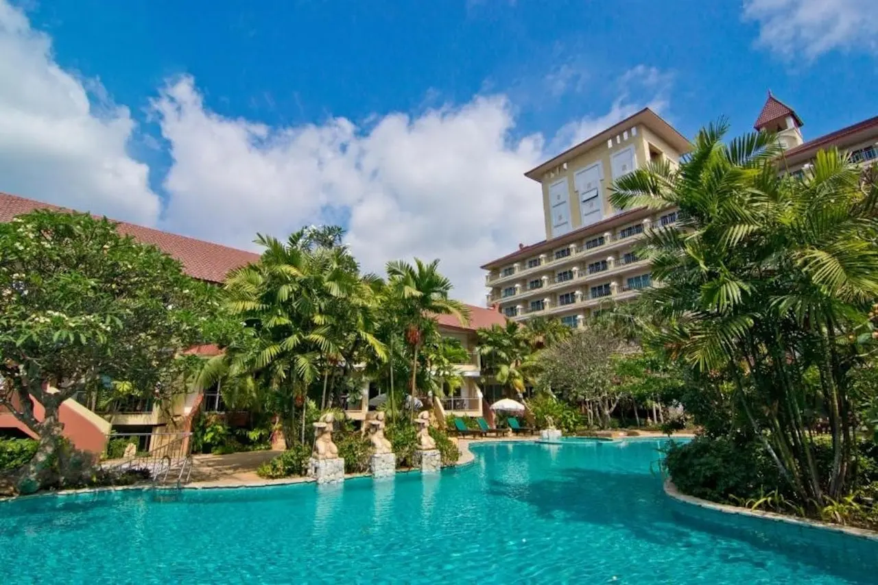 Weitläufiger Pool mit dem Bella Villa Cabana Hotel im Hintergrund und tropischer Gartenanlage – entspannte Atmosphäre in Pattaya.