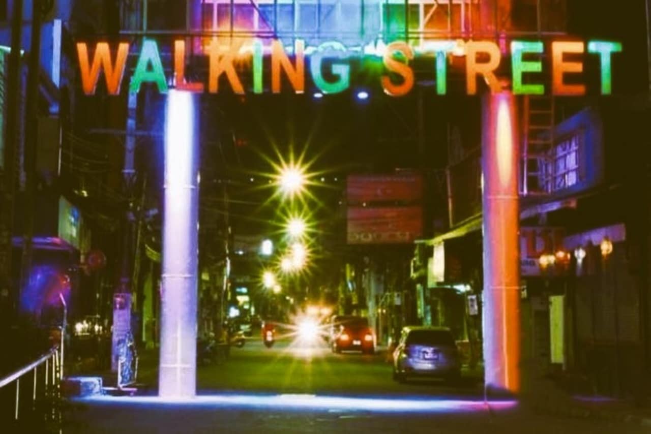 Beleuchteter Eingang der Walking Street in Pattaya bei Nacht mit vielen Besuchern und bunten Neonlichtern.