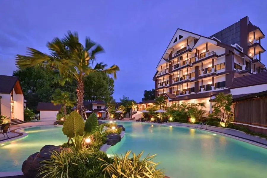 Kastel Pattaya Hotel – großer beleuchteter Pool mit viel Grün und Hotelgebäude im Hintergrund